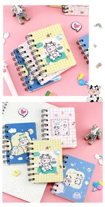 Close-up showing the cover details of mini cow-themed spiral notebooks in pastel shades