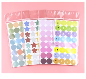Detailopname van vier kleurrijke stickervellen met stippen, sterren en blije smileys.