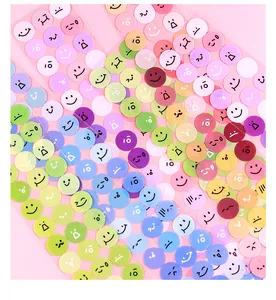Macro detail of colorful waterproof round stickers with various cute emoji expressions.