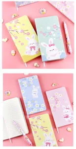 Niedliches Notizbuch mit Hasenmotiv und Kirschblüten auf pastellrosa Hintergrund