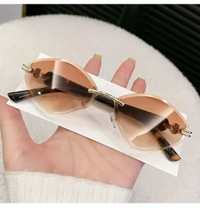 Close-up of rimless diamond-cut sunglasses with gradient tea lenses and gold metal arms