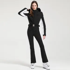 Combinaison de ski une pièce pour femme noir et blanc avec bordure en fausse fourrure.