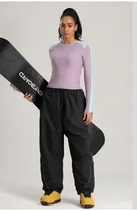 Vista detallada de pantalones de esquí cargo negros para mujer y top térmico púrpura