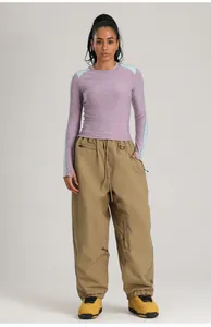 Vista completa de modelo con pantalones de esquí cargo caqui impermeables y cortavientos
