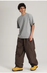 Pantalón de esquí marrón holgado para hombre con cordón, lucido por un modelo.