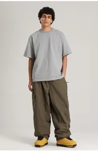 Vue professionnelle complète d'un pantalon de ski cargo vert olive ample sur un mannequin homme