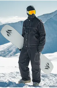 Vista completa di una tuta da sci nera retrò in stile workwear per uomo sulla neve.