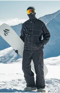 Modello professionale che indossa una tuta da sci nera in stile retrò workwear in montagna