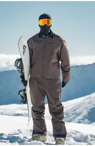 Completo da snowboard marrone retrò da uomo giacca e pantaloni su una montagna innevata