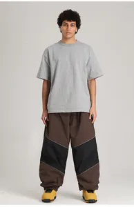 Männliches Model trägt wasserdichte Color-Block-Skihose in Übergröße im Profi-Studio