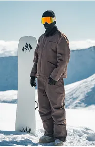 Dettaglio di un uomo che indossa una tuta da sci marrone in stile americano sulla neve