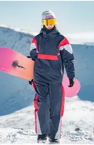 Outdoor-Detail eines wasserfesten Farblock-Skianzugs für Damen und Herren im Schnee.