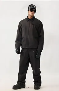 Completo da sci vintage nero da uomo, giacca impermeabile e pantaloni coordinati.