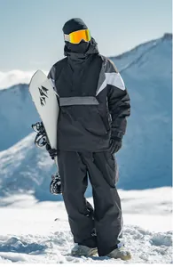 Detailansicht eines wasserdichten, isolierten Snowboard-Anzugs in einer verschneiten Berglandschaft