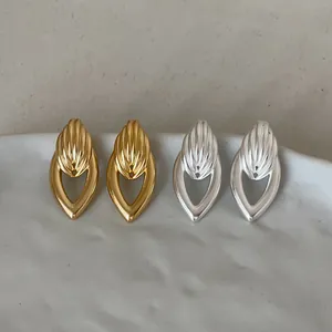 Vue détaillée de boucles d'oreilles géométriques en forme de goutte en tons or et argent