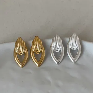 Vue détaillée de boucles d'oreilles géométriques dorées et argentées en forme de goutte