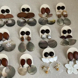 Macro shot of various vintage earrings featuring shell and wood elements on display