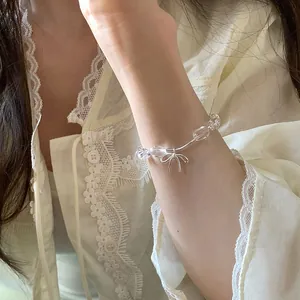 Elegante braccialetto di perline trasparenti con delicato ciondolo a fiocco argento