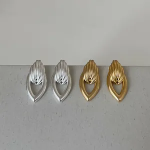 Gros plan de boucles d'oreilles dorées et argentées en forme de goutte d'eau.