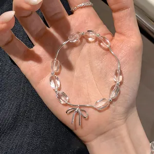 Primo piano di bracciale con perline trasparenti e fiocco d'argento