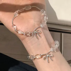 Elegante vista ravvicinata di due braccialetti di perle trasparenti con fiocchi d'argento
