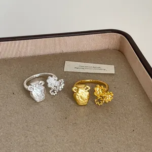 Macro view of French style textured gold and silver rings with floral vase design