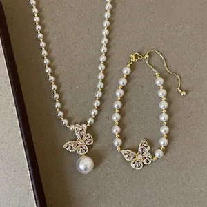 Detaillierte Nahaufnahme des Perlen-Schmucksets mit rosa Schmetterlingsanhänger für Damen