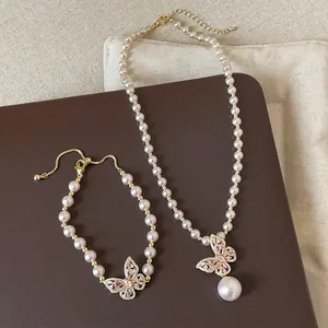 Französisches Schmuckset mit Perlenkette und Armband sowie rosa Kristallschmetterlingen.