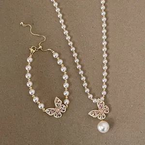 Nahaufnahme von Perlenhalskette und Armband-Set mit rosa Schmetterlingsanhängern