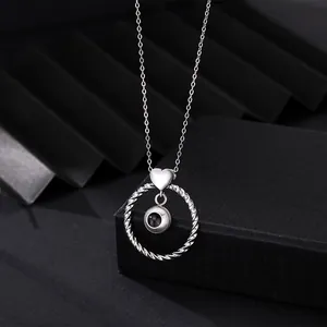 Detailed macro shot of silver heart and twisted circle projection necklace pendant