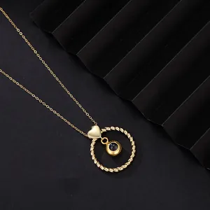 Macro view of the golden projection necklace featuring a twisted ring and heart bail detail.