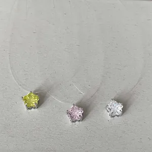Gros plan de pendentifs en zircone colorée en forme d'étoile sur des colliers invisibles