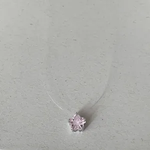 Gros plan d'un pendentif en zircone rose en forme d'étoile sur un collier invisible