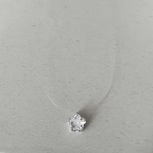 Gros plan d'un pendentif en zircon en forme d'étoile sur un collier en fil de pêche invisible