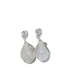 Pendientes plateados con capas de hojas de nácar y una circonita en forma de gota.
