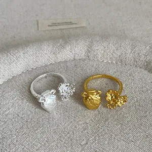 Detail of French style textured metal rings with miniature vase and flower design