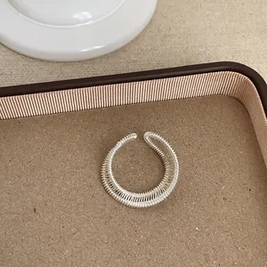 Detailansicht der filigranen, gewickelten Silberdraht-Textur eines minimalistischen Rings.