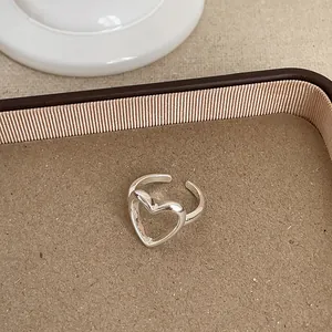Detailansicht eines minimalistischen silbernen offenen Rings mit hohlem Herz-Design