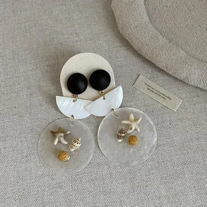 Close-up of retro shell and wood earrings with starfish and seashell charms