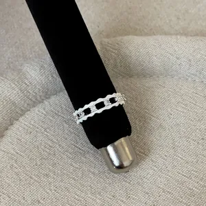 Close-up of elegant silver lace openwork ring with sparkling stone inlays