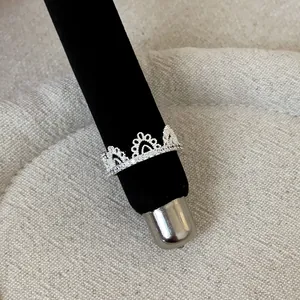 Close-up detail of an elegant silver lace hollow crown ring set with small cubic zirconia