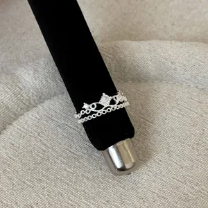 Macro view of a silver French lace hollow ring with a crown design and clear stone