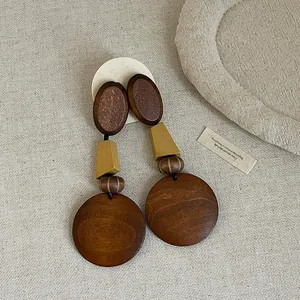 Close-up of vintage wooden geometric earrings with natural textures and mustard yellow accent