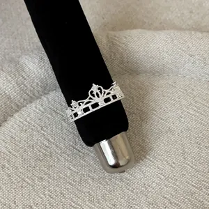 Elegant silver lace hollow crown ring with sparkling crystals on black velvet display