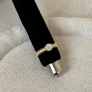 Detailed macro view of an elegant gold lace openwork ring featuring a white stone center
