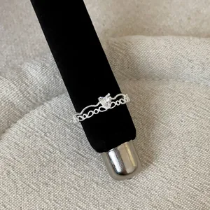 Macro detail of a silver French lace hollow ring featuring a sparkling heart-shaped stone