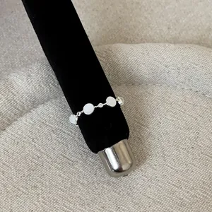Detailed macro view of a silver lace ring featuring white round inlays and dainty stones
