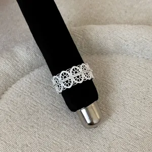 Detailed close-up showing the intricate lace pattern of the silver hollow-out ring