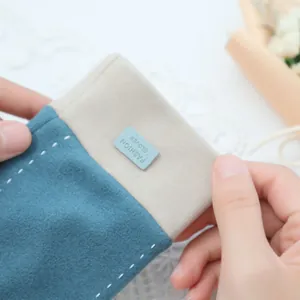 Close-up detail of soft blue and beige warm winter gloves with double white stitching