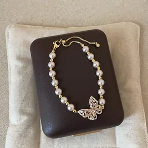 Detailansicht des eleganten Perlenarmbands mit einem rosa Schmetterlingsanhänger